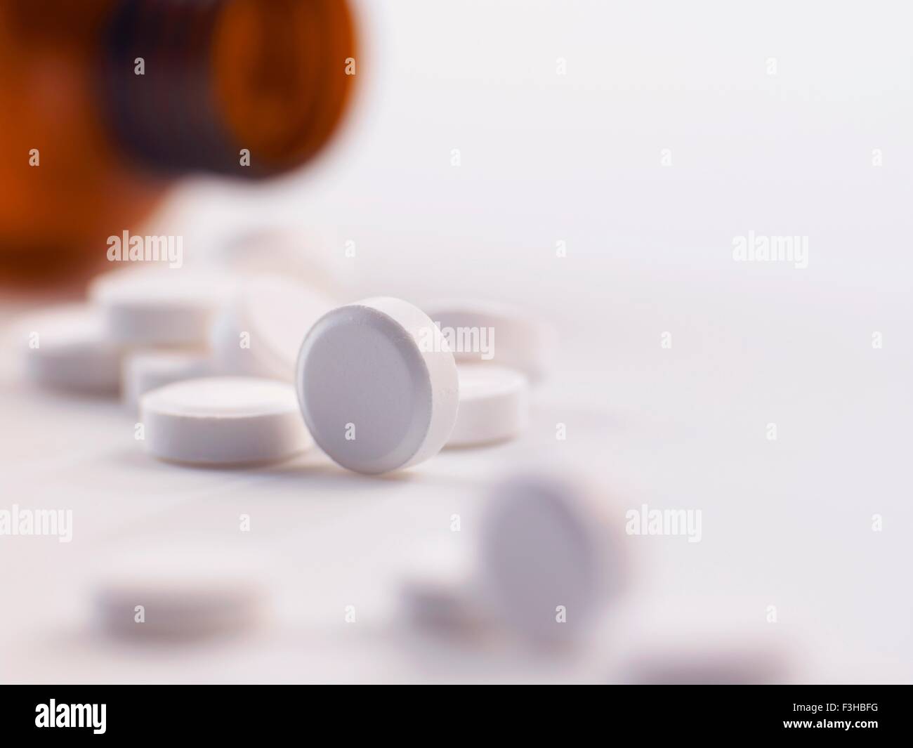 Pain killer pills spilling out of a bottle Stock Photo