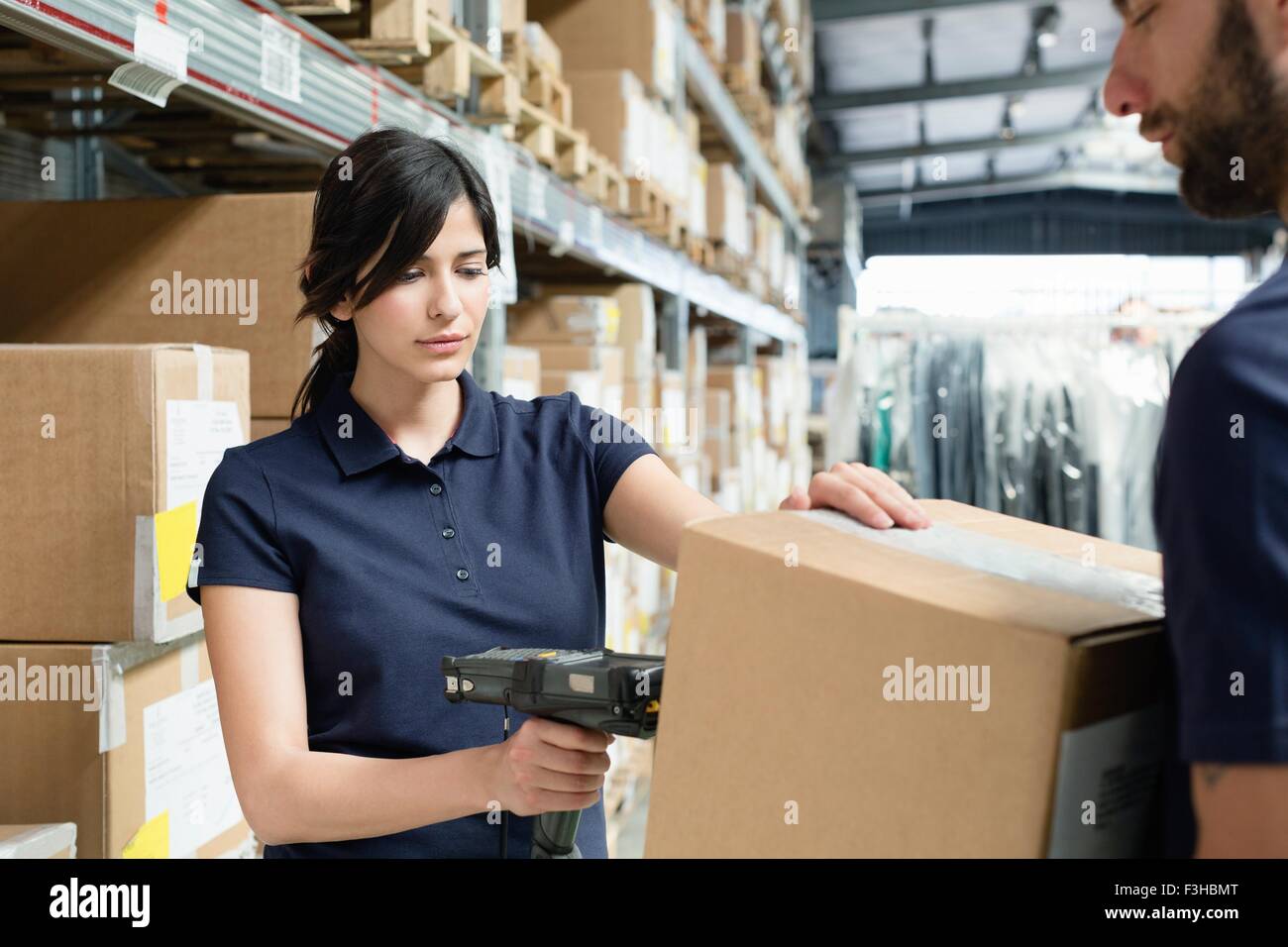 Warehouse workers using barcode scanner on box in distribution warehouse Stock Photo