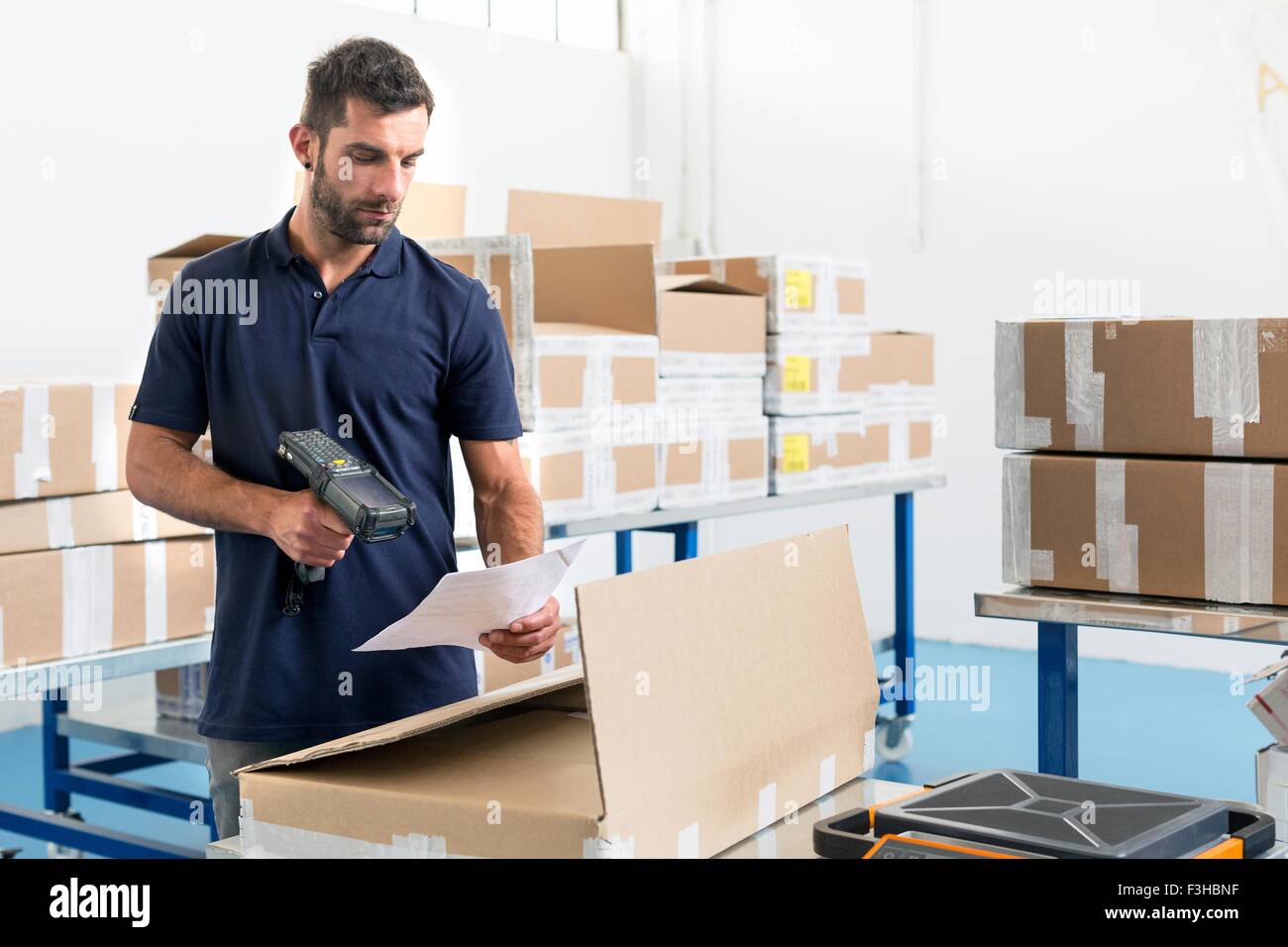 Warehouse worker scanning paperwork in distribution warehouse Stock Photo