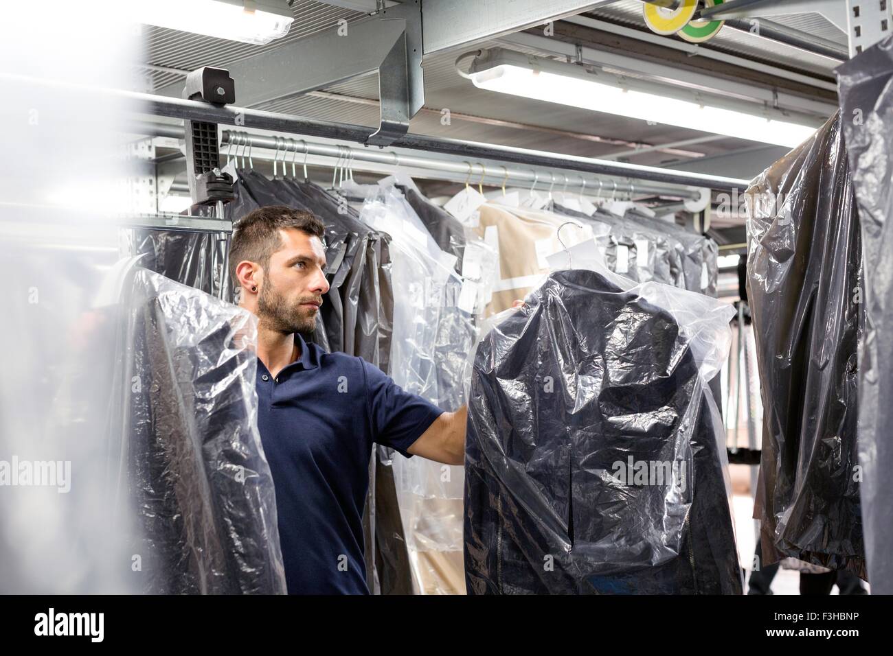 Male warehouse worker doing garment stock take in distribution warehouse Stock Photo Alamy