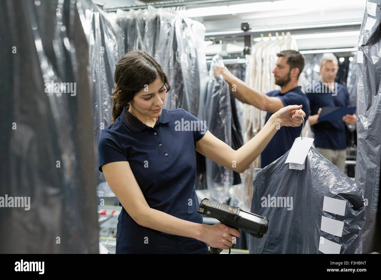 Three warehouse workers doing garment stock take in distribution warehouse Stock Photo