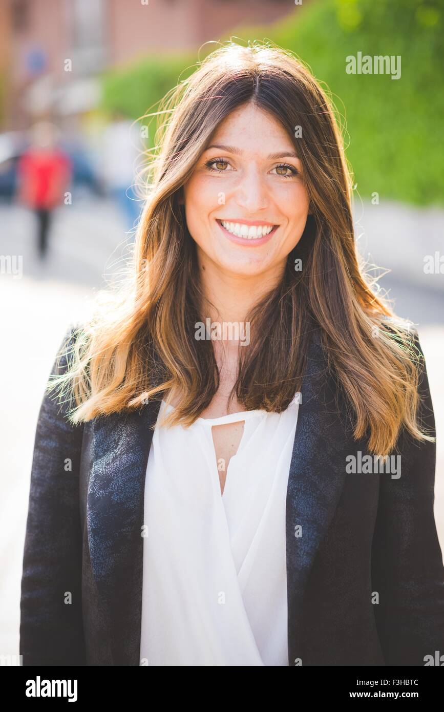 Portrait of happy young woman with long brown hair Stock Photo - Alamy