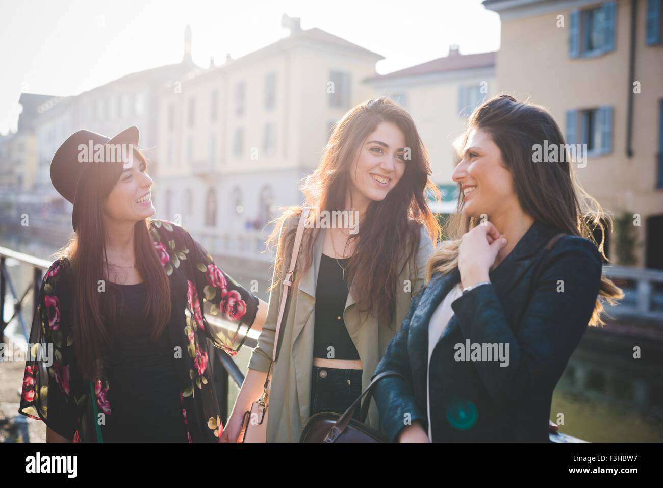 Three young women chatting on canal waterfront Stock Photo