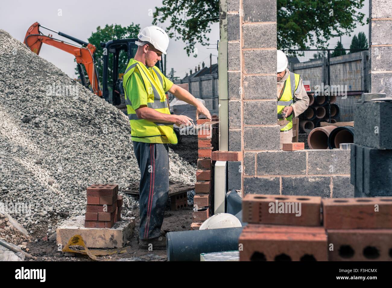 Workers laying bricks on construction site Stock Photo