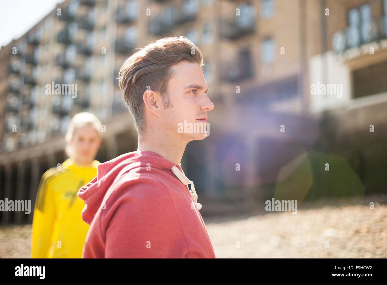 Runners standing by building block, Wapping, London Stock Photo