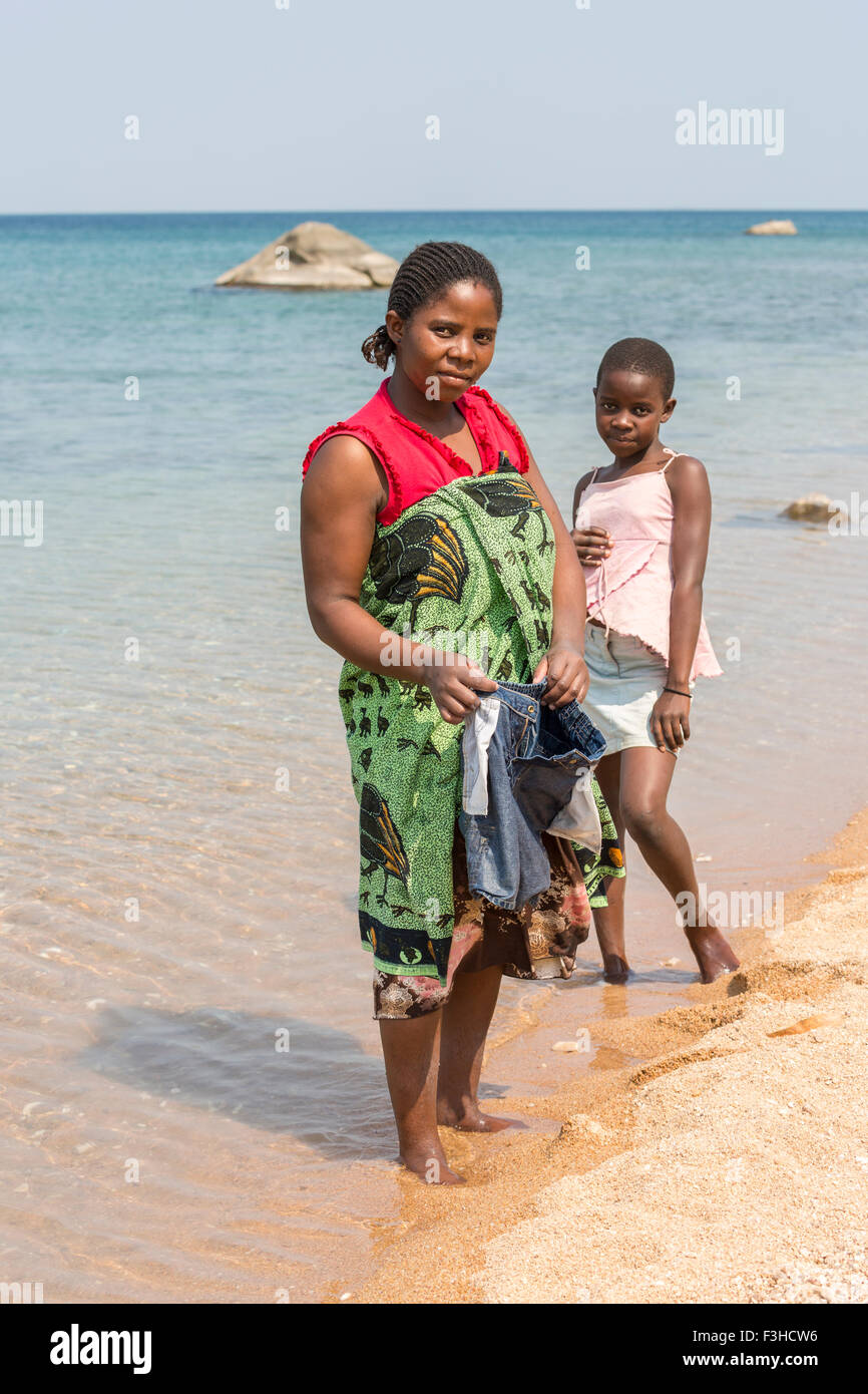 Local lifestyle: African woman and her daughter washing clothes on the beach, Kaya Mawa, Likoma Island, Lake Malawi, Malawi, Africa Stock Photo
