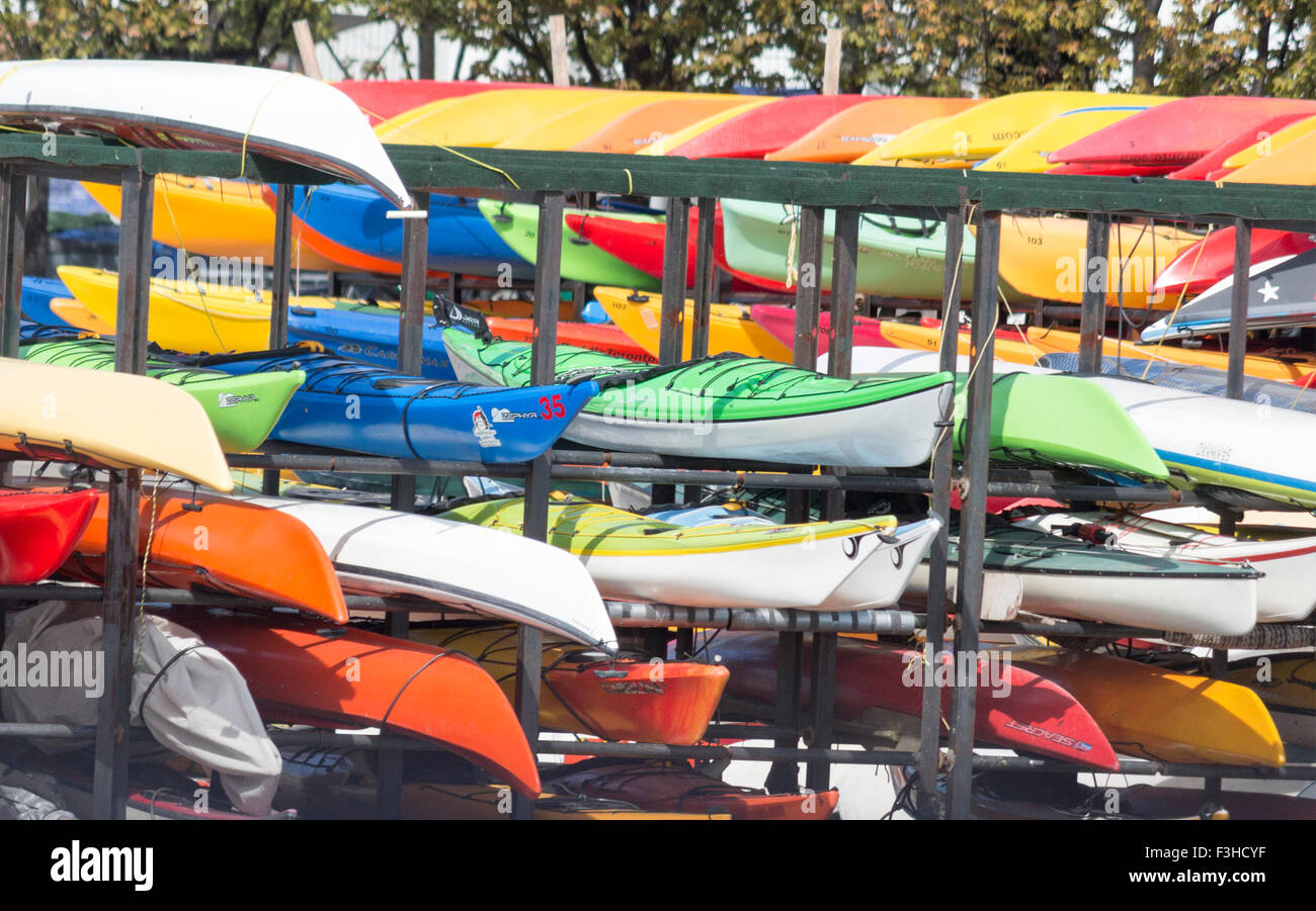 Bright coloured canoes and kayaks stacked up on the waterfront at