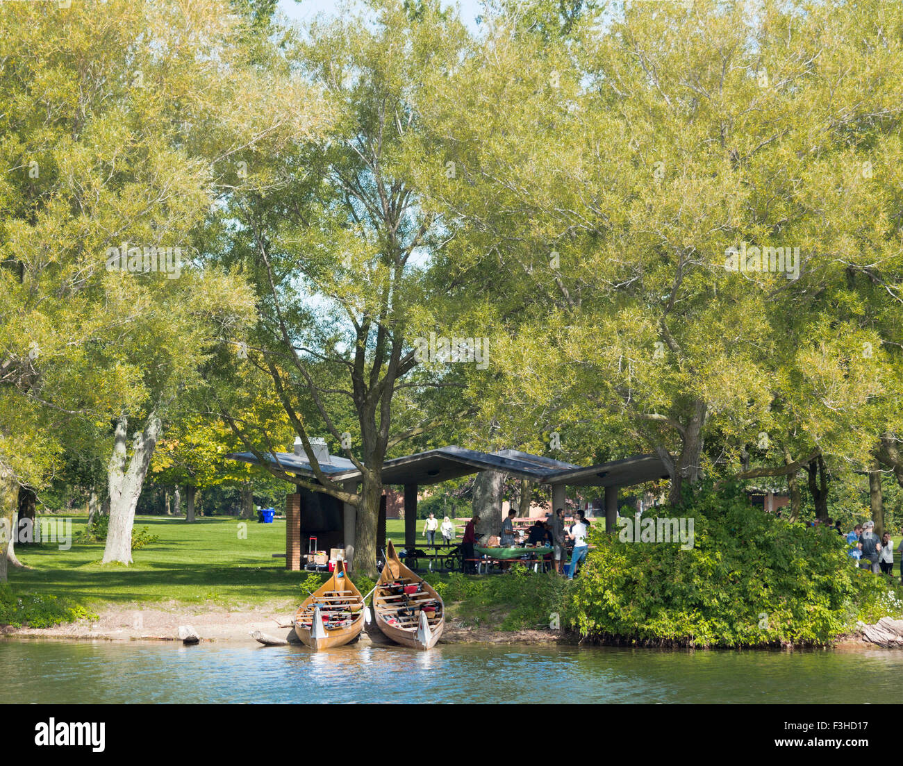 Families enjoying a picnic on Centre Island in the Toronto Islands in Toronto, Ontario, Canada with canoes on the beach Stock Photo