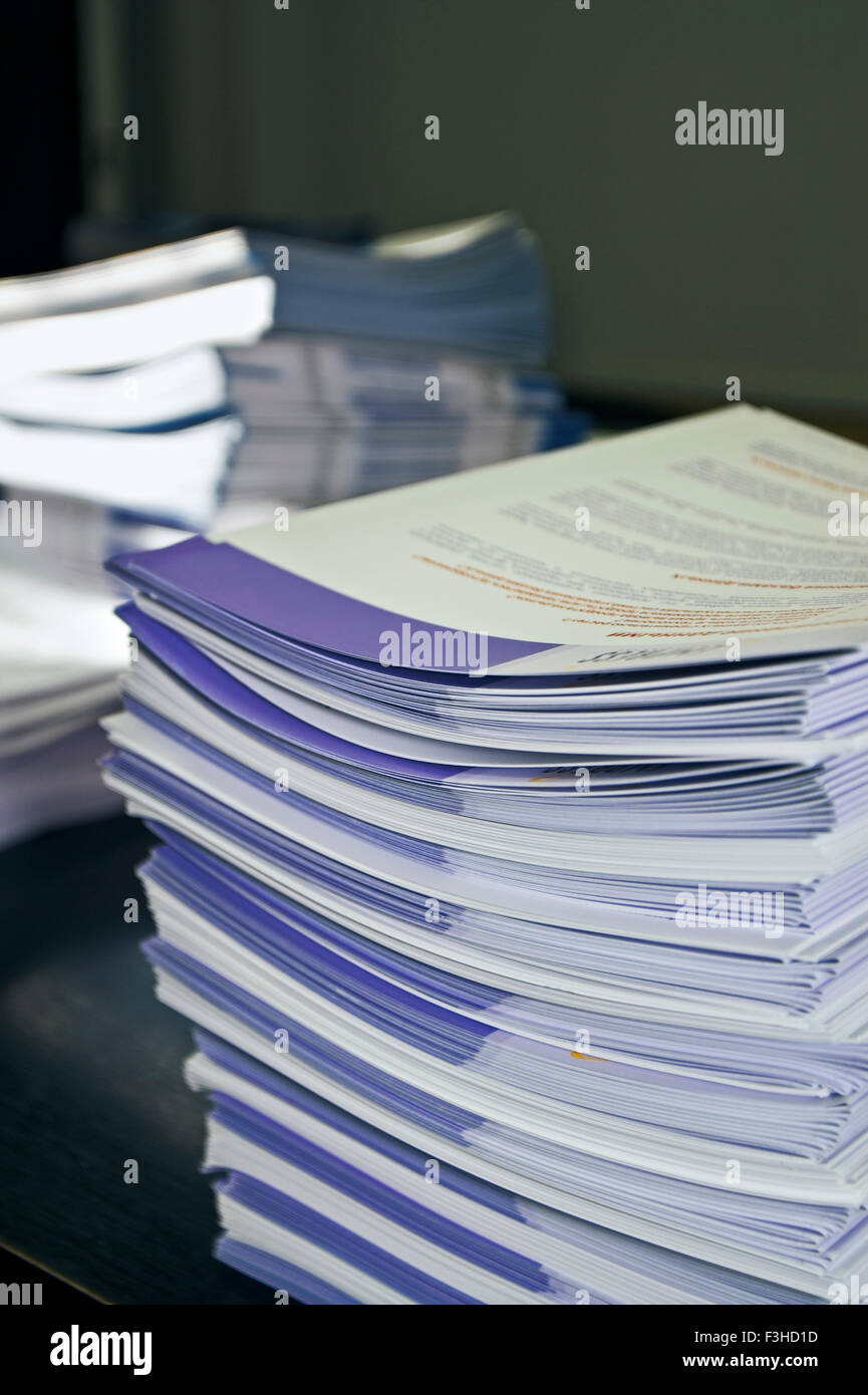 Piles of handout papers lying on a table. Stock Photo