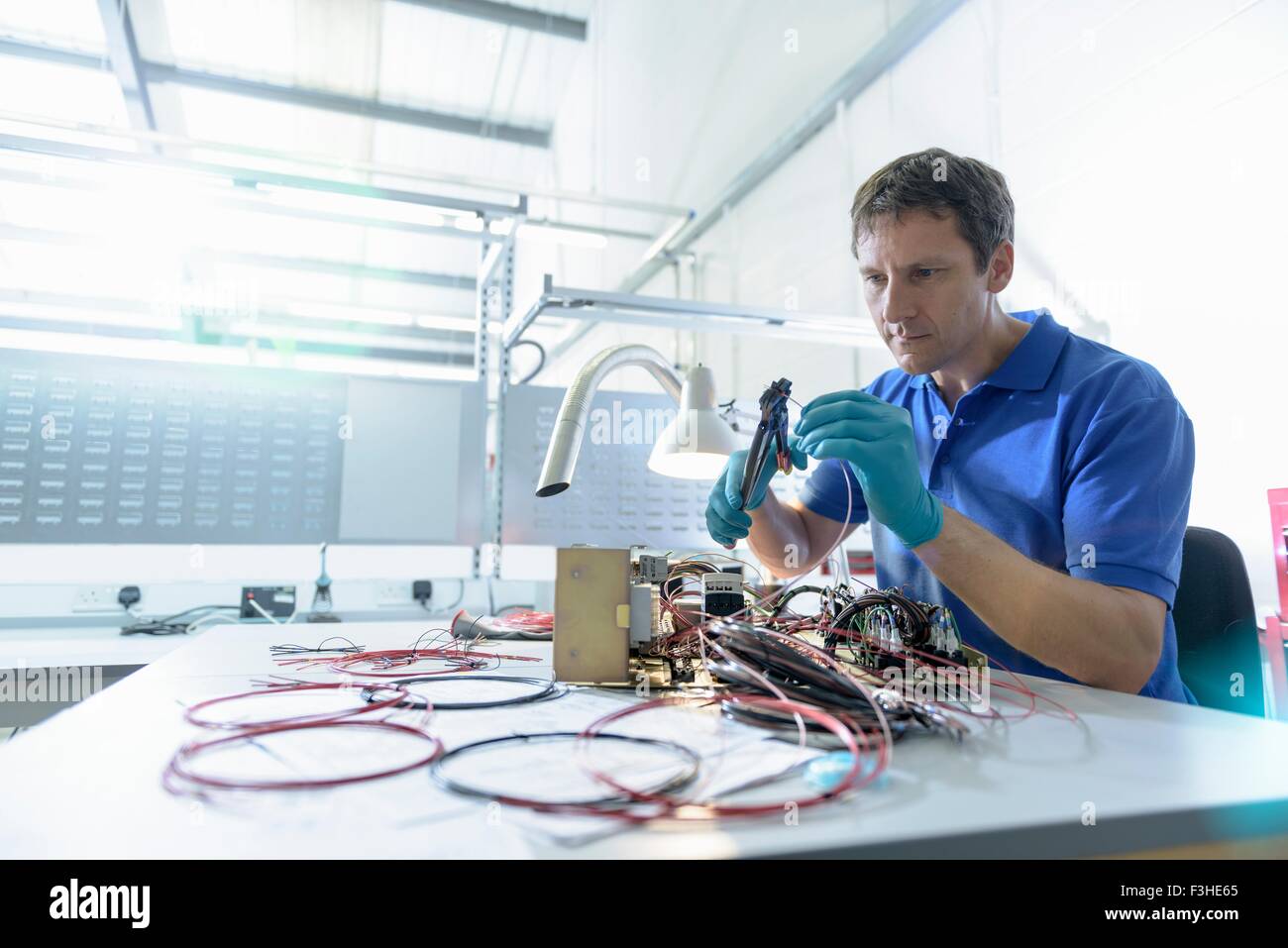 Worker assembling electronics in electronics factory Stock Photo