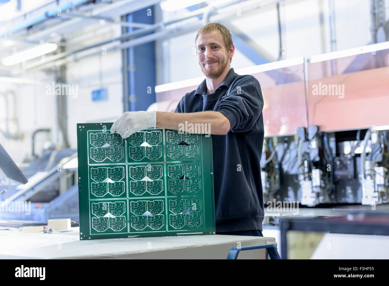 Worker cutting circuit boards in circuit board factory, portrait Stock