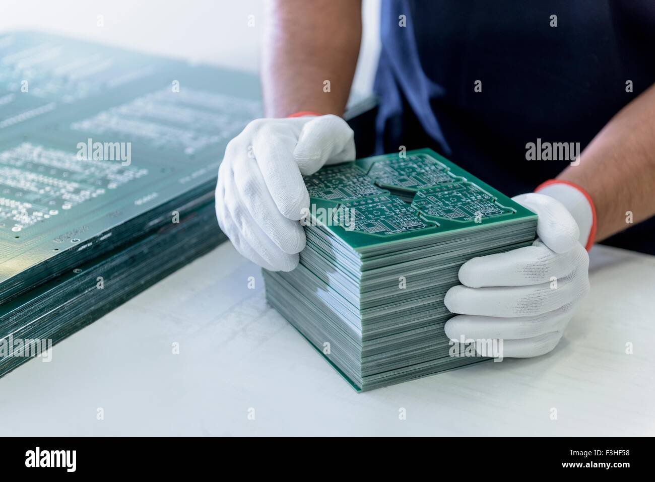 Worker arranging cut circuit boards in circuit board factory Stock Photo