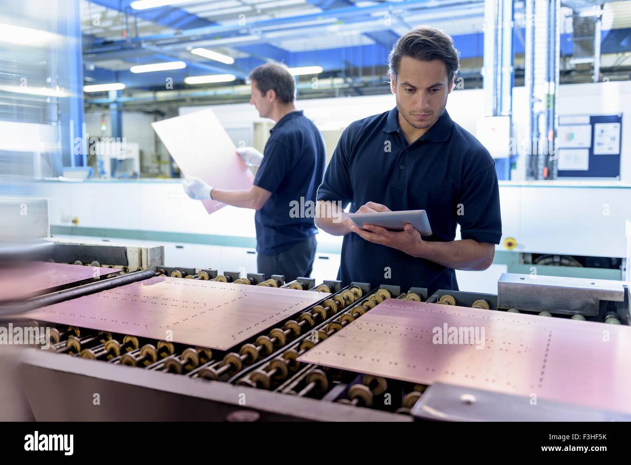 Workers inspecting circuit board during manufacture in circuit board factory Stock Photo