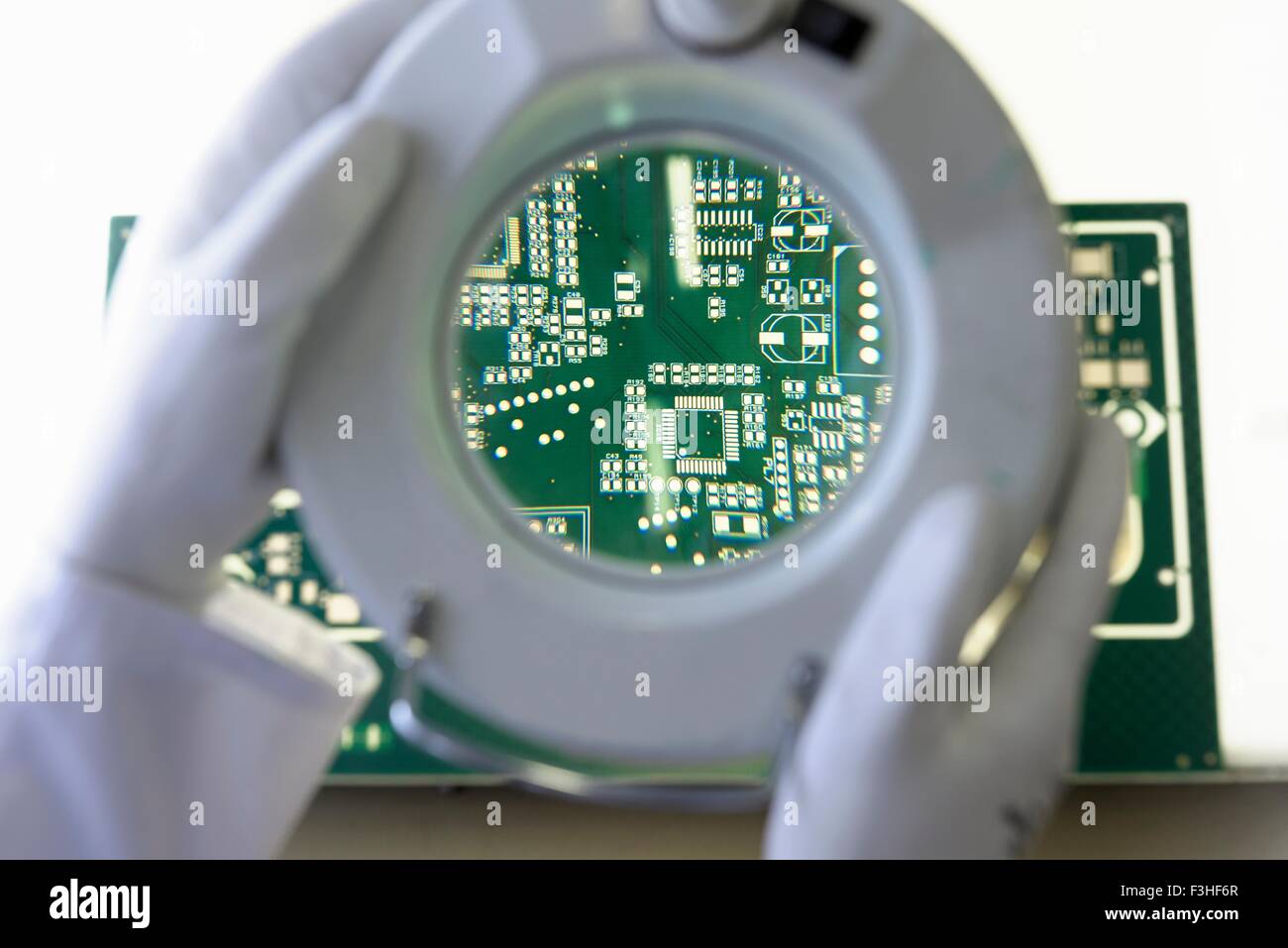 Green circuit board under inspection magnifier in circuit board factory Stock Photo
