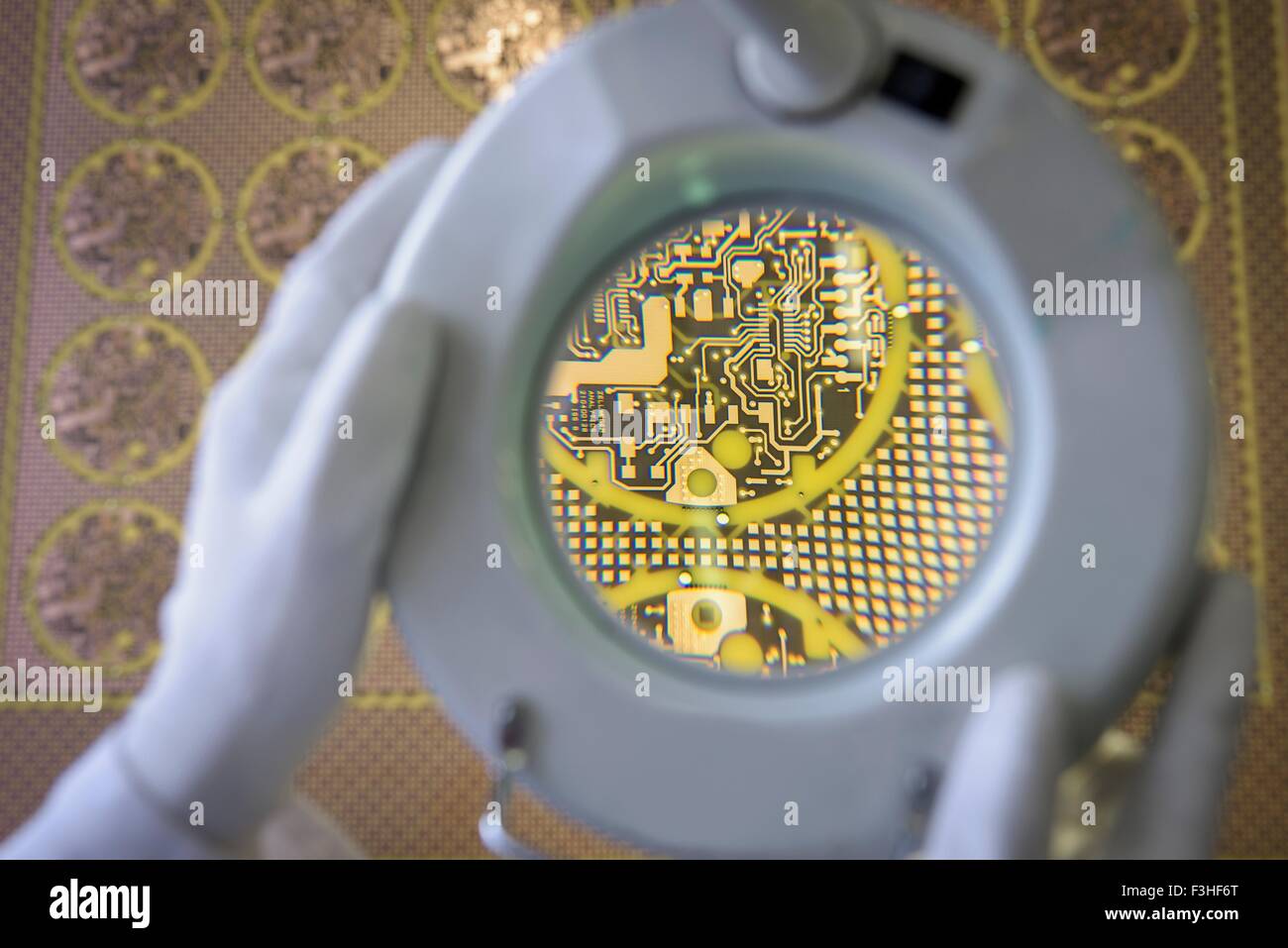 Yellow circuit board under inspection magnifier in circuit board factory Stock Photo