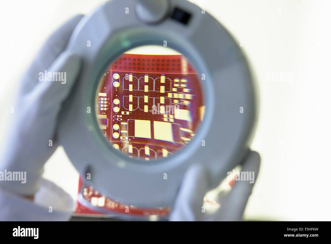 Red circuit board under inspection magnifier in circuit board factory Stock Photo