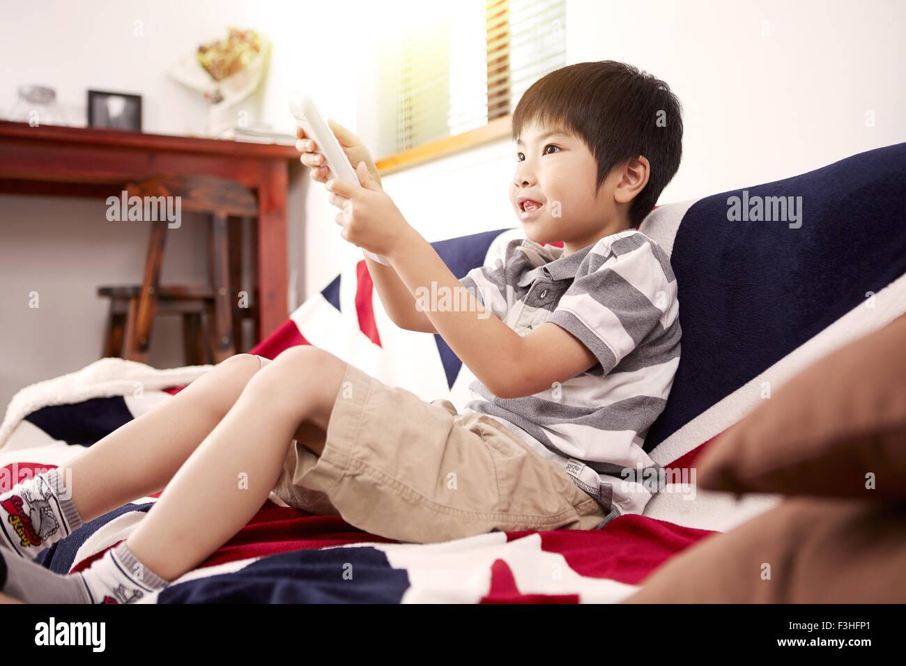 Young boy sitting on sofa watching the television at home Stock Photo ...