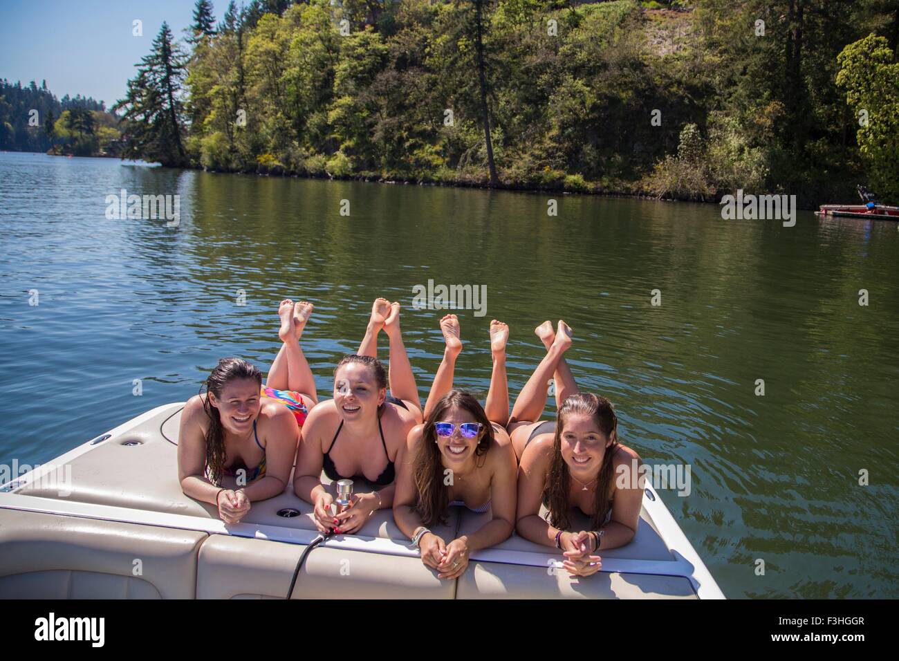 Portrait of four young women lying on motorboat at Lake Oswego, Oregon, USA Stock Photo