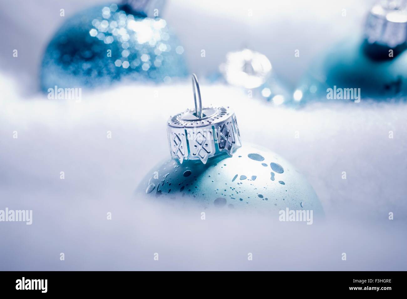 Cropped shot of blue sparkly Christmas baubles nested is fake snow Stock Photo
