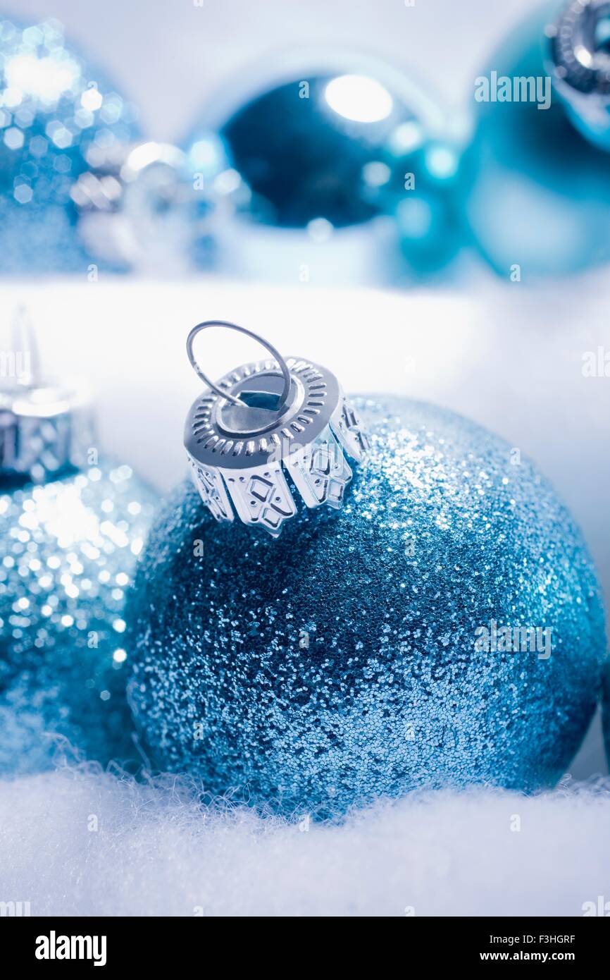 Cropped shot of blue sparkly Christmas baubles nested is fake snow Stock Photo