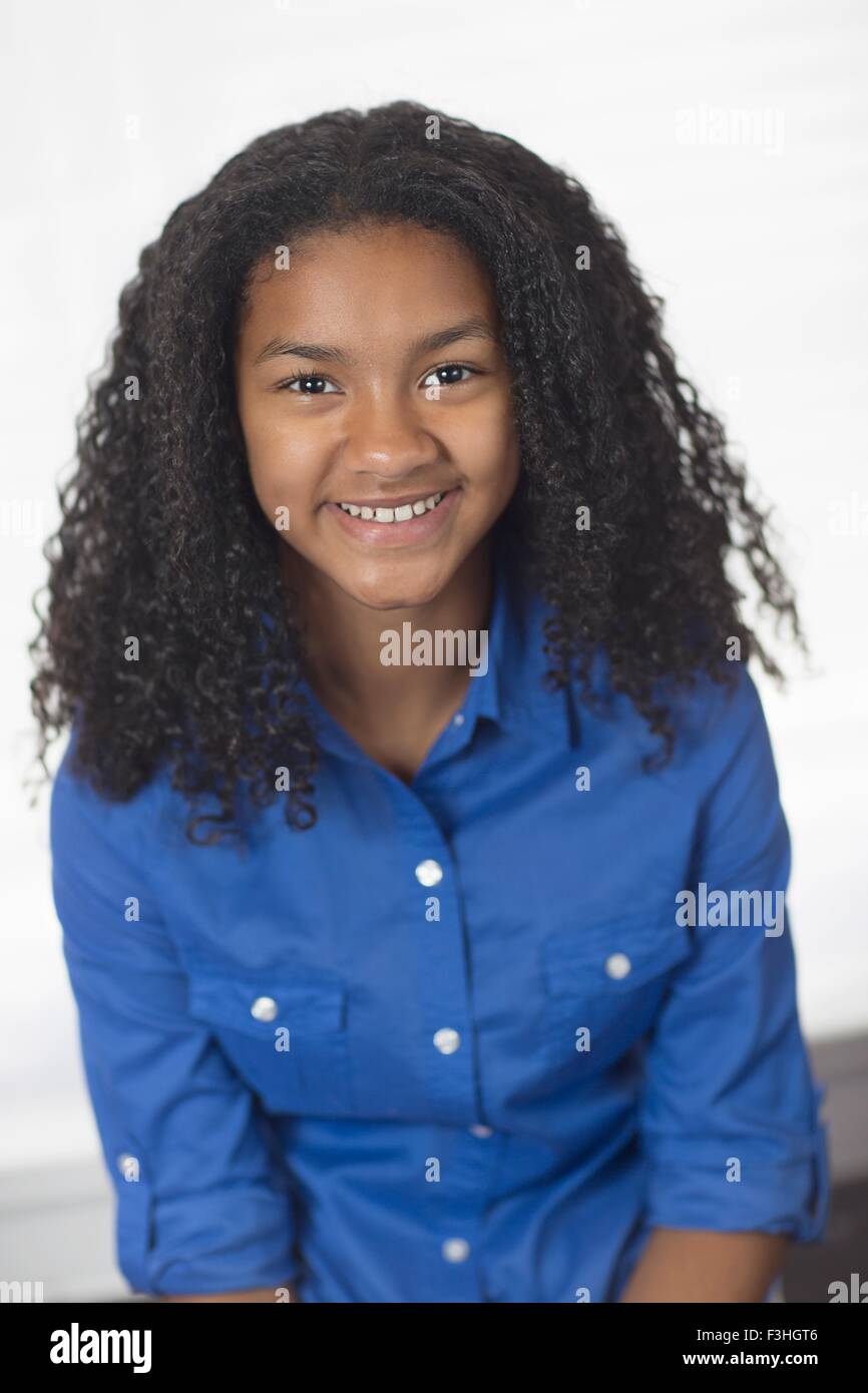Portrait of girl with curly black hair looking at camera smiling Stock Photo
