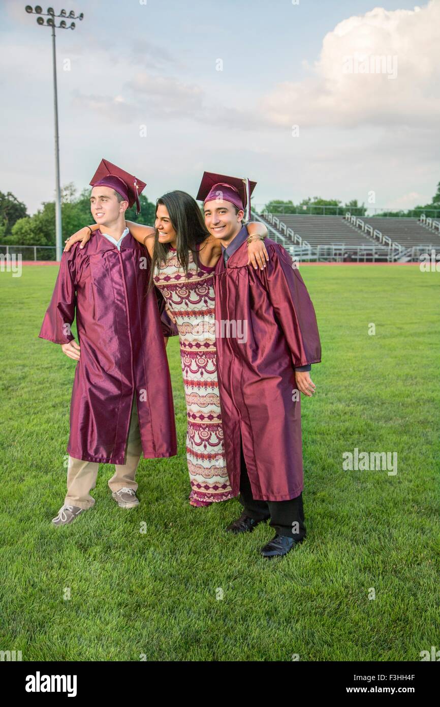 Students celebrate graduation with friend Stock Photo