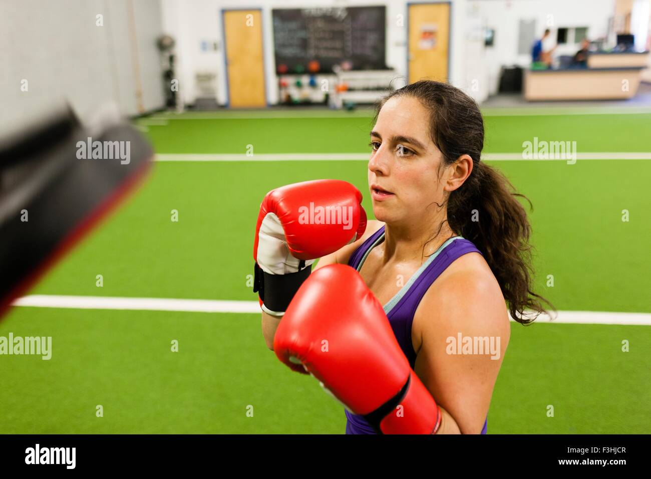 Mid adult woman wearing boxing gloves, working out in gym Stock Photo ...