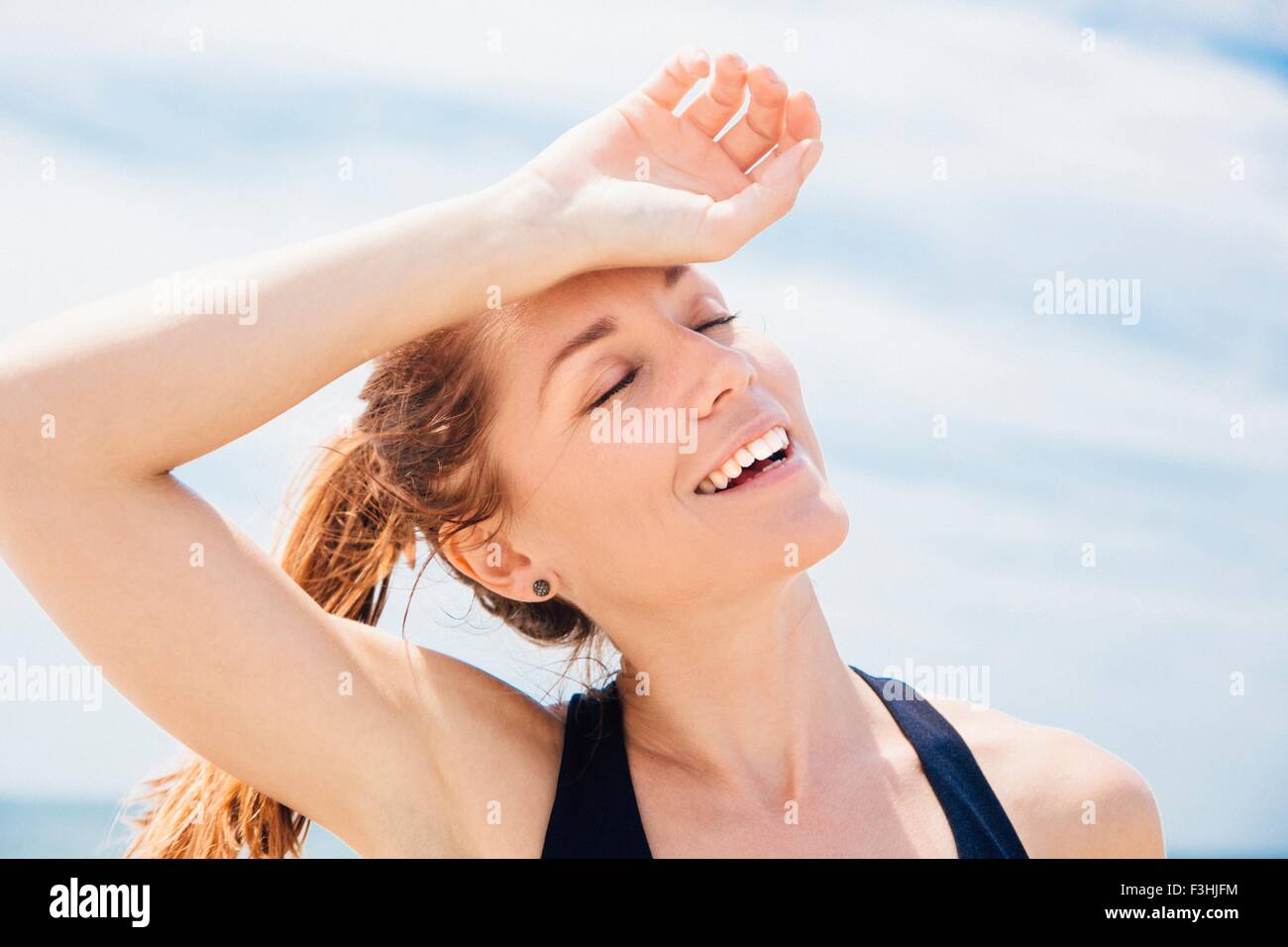 Mid adult woman on beach, arm resting on head Stock Photo Alamy