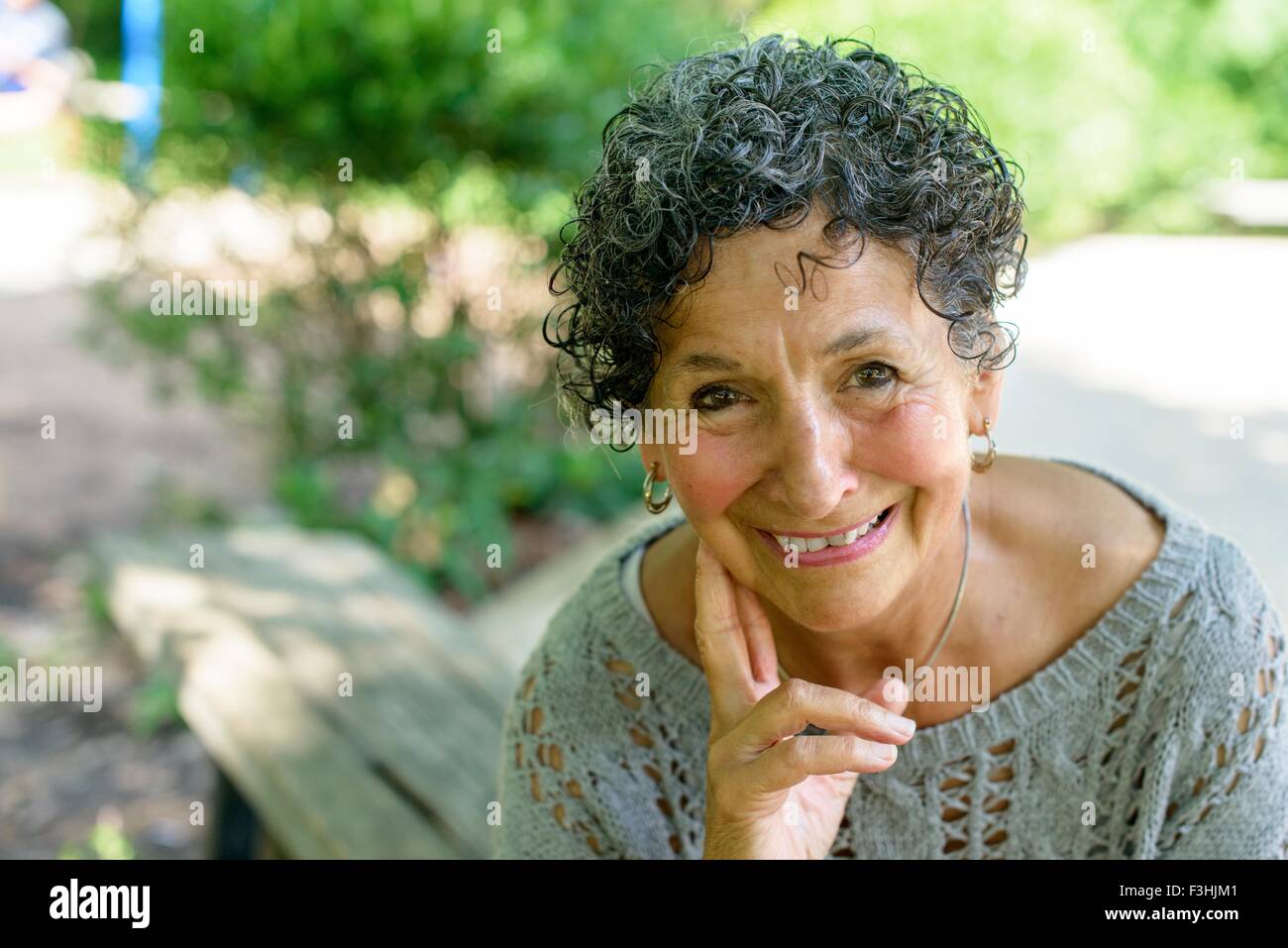 Portrait of senior woman sitting in park Stock Photo