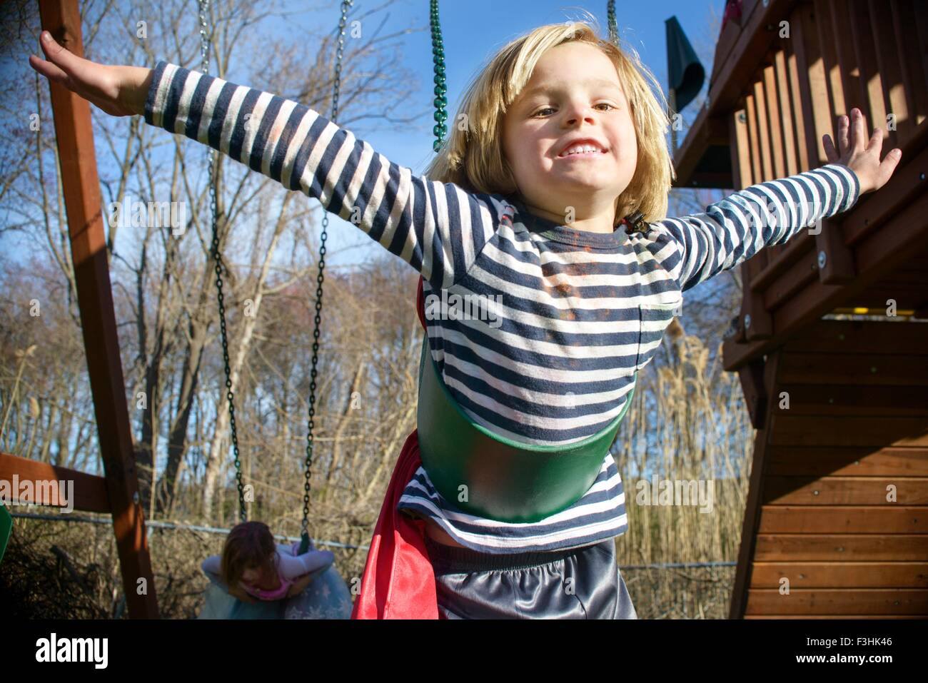 Boy with red cape pretending to fly Stock Photo