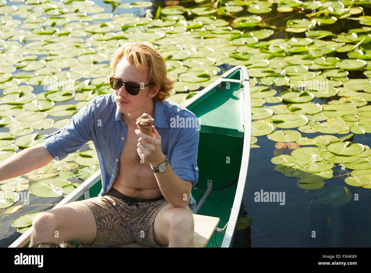 Man eating on rowboat in lake, Seattle, Washington, USA Stock Photo