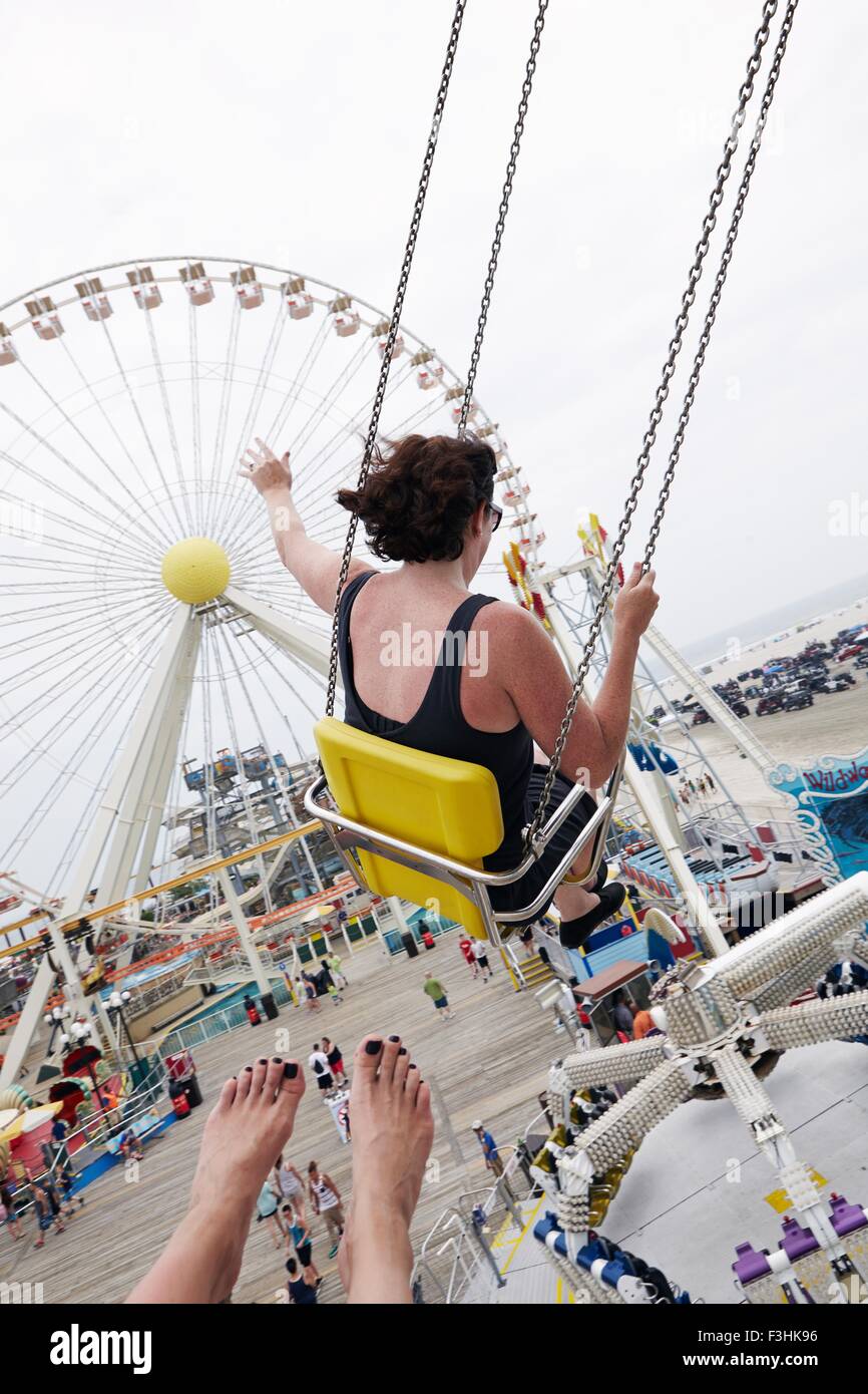 Woman waving from amusement park swings Stock Photo