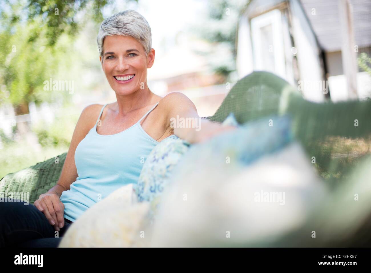 Portrait of mature woman relaxing on garden seat Stock Photo