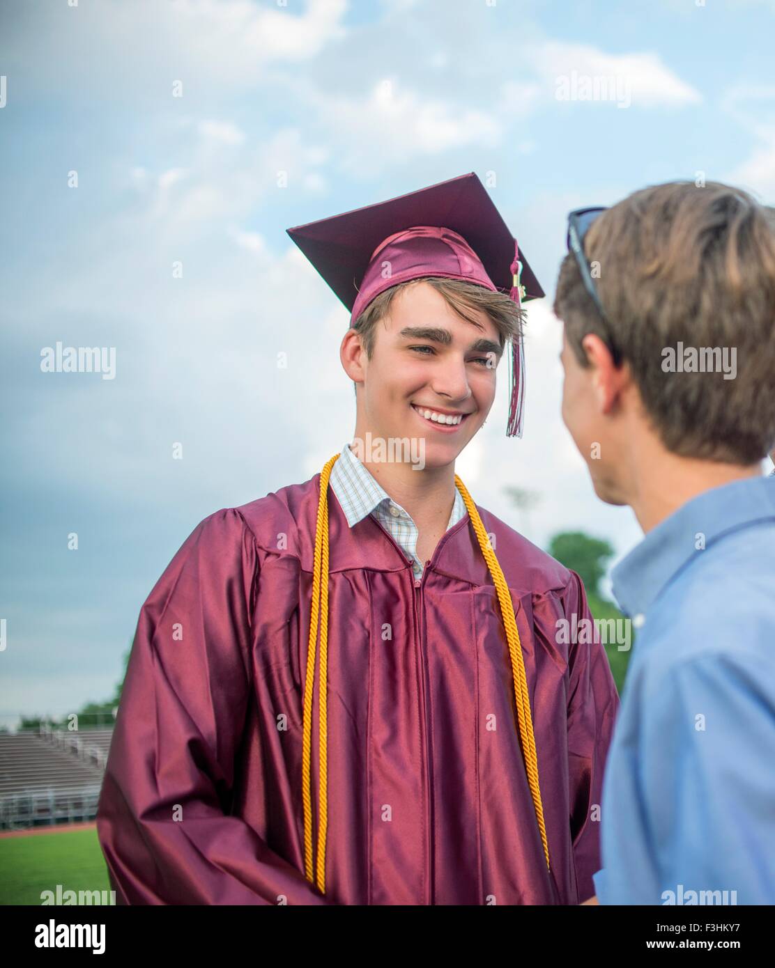 Young man with family memeber at graduation ceremony Stock Photo