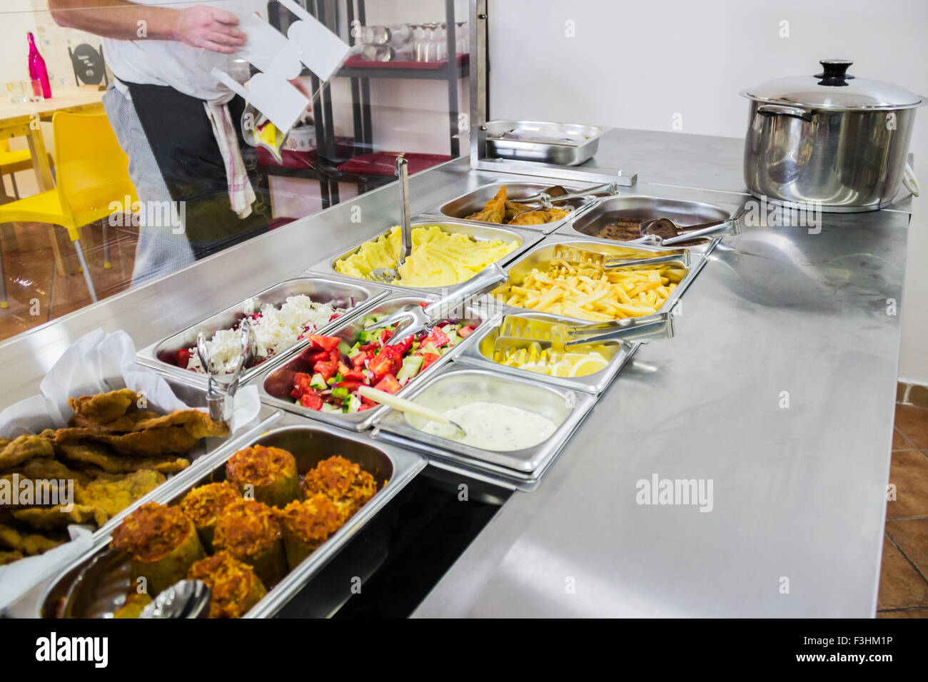 Food bar in a cafeteria with fresh meals, mixed salads and dressings Stock Photo
