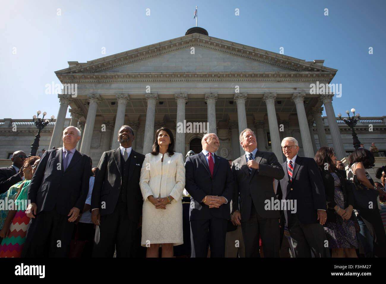 South Carolina Governor Nikki Haley is joined by politicians to watch the removal of the Confederate Flag from the State House July 10, 2015 in Columbia, South Carolina.  Joining Haley are (L to R):  Former Governor Jim Hodges, Emanuel AME Rev. Norvel Goff, Governor Nikki Haley, First Gentleman Michael Haley, Governor David Beasley, and Charleston Mayor Joe Riley. Stock Photo