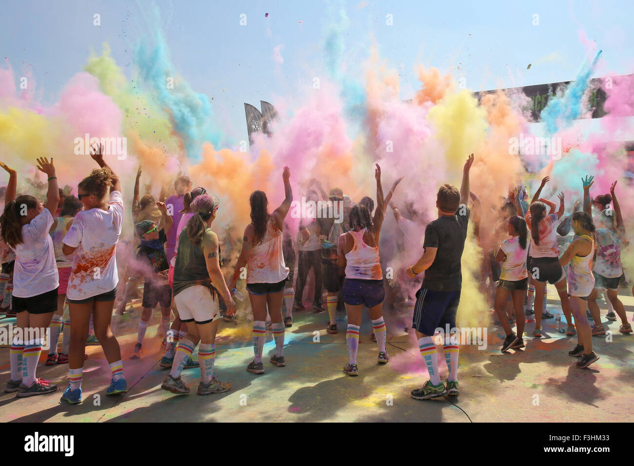 Runners toss colorful powder into the air at the conclusion of the Color Me Rad 5k Fun Run August 22, 2015 in Miramar, California. The run involves participants being showered in colored powder, made of food-grade corn starch and is taken from the Indian festival of Holi. Stock Photo