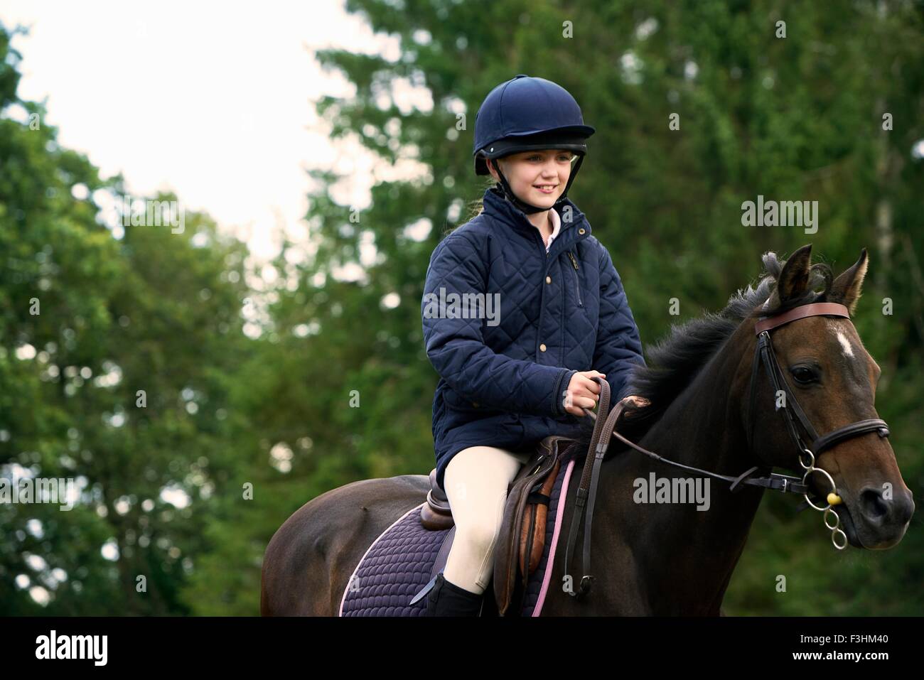 Girl horseback riding in countryside Stock Photo