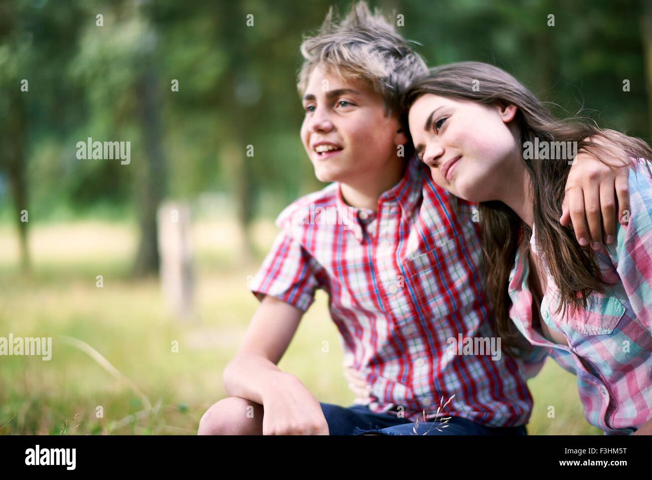 Portrait of teenage boy with arm around sister Stock Photo