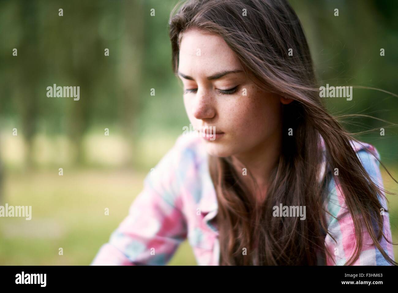Portrait of teenage girl looking downward in woodland Stock Photo