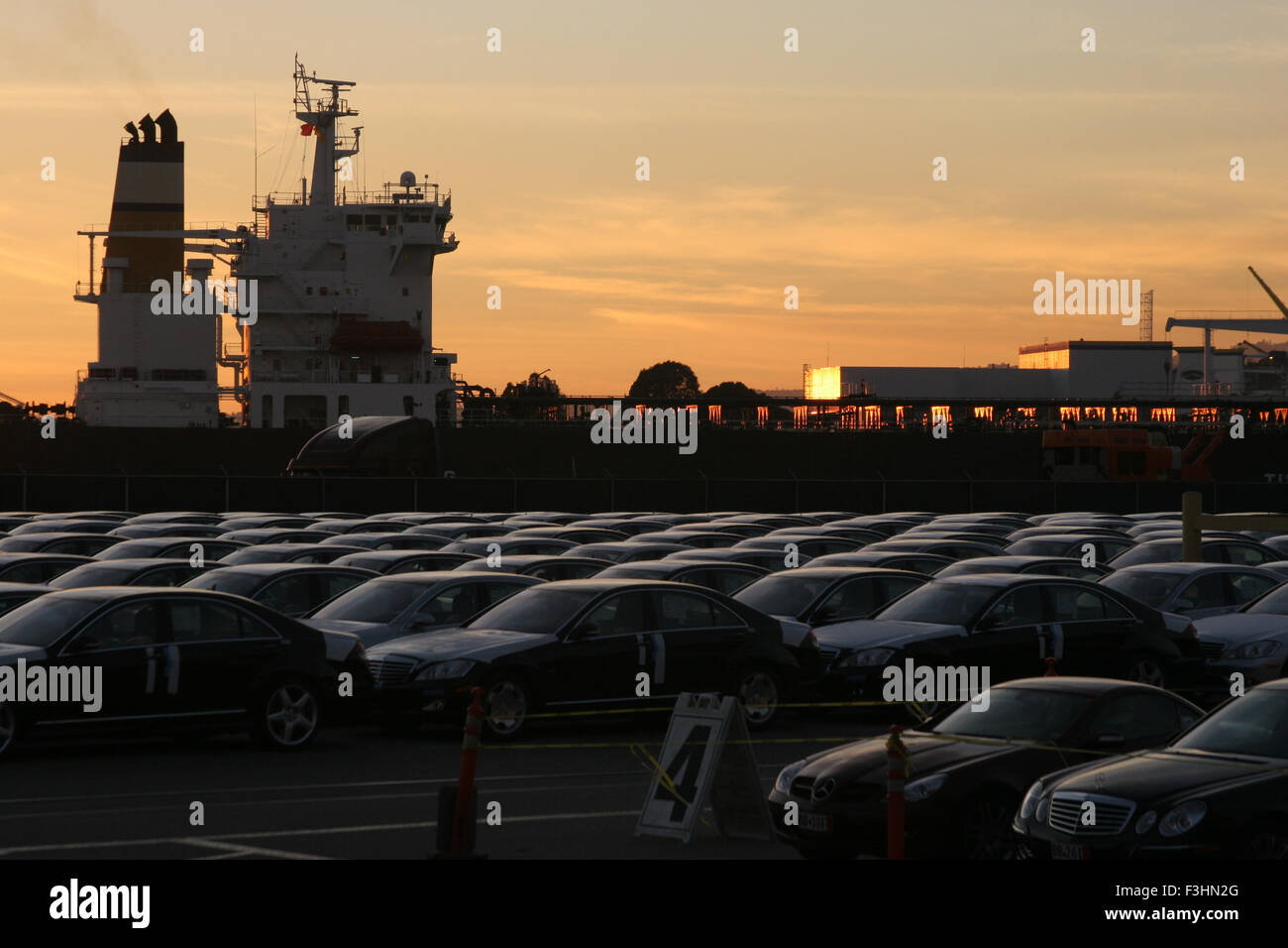 car/auto storage facility for transport with ship at sunset Stock Photo