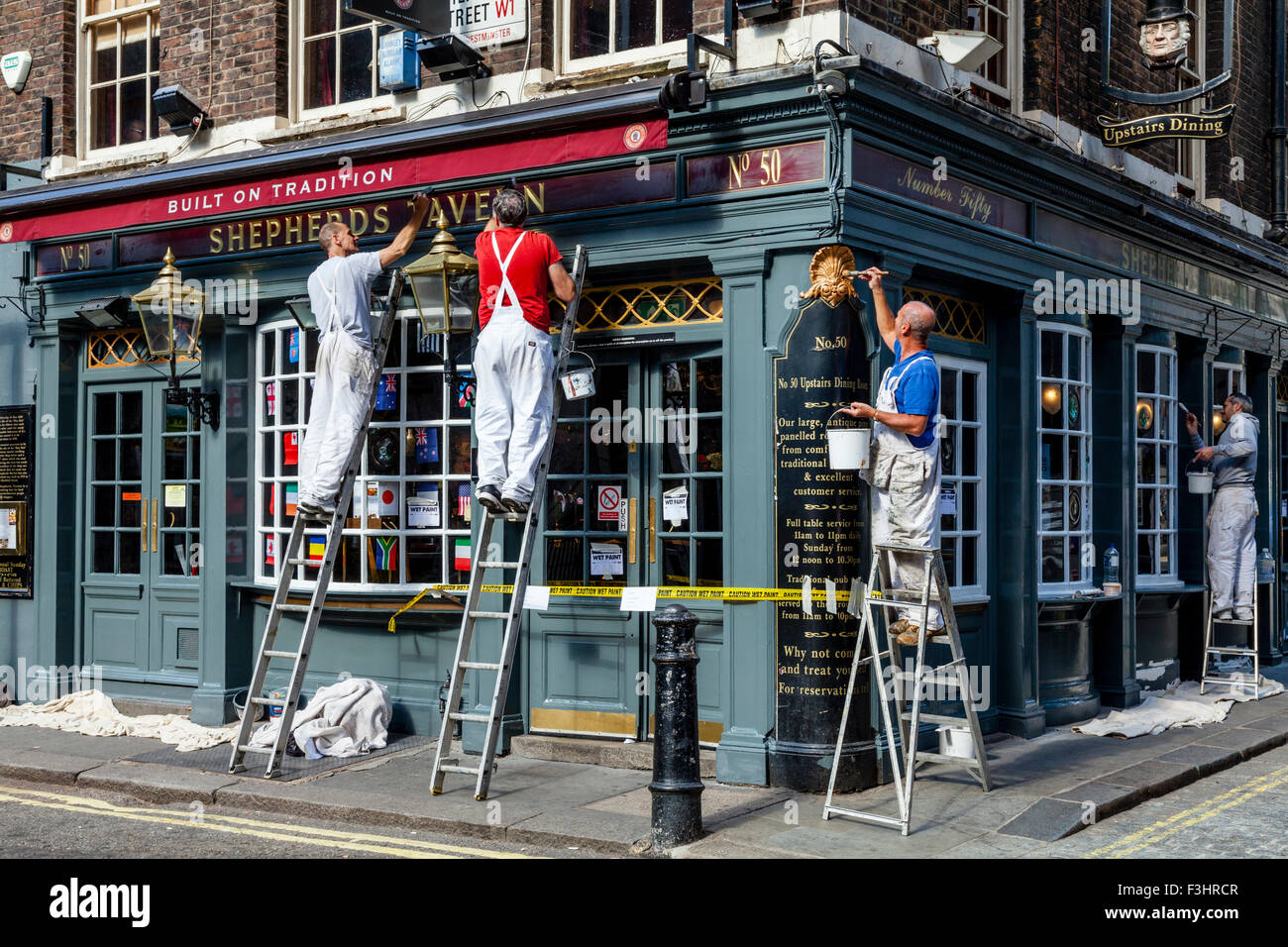 Painters and Decorators Painting A Pub Exterior, Shepherd Market, London, UK Stock Photo