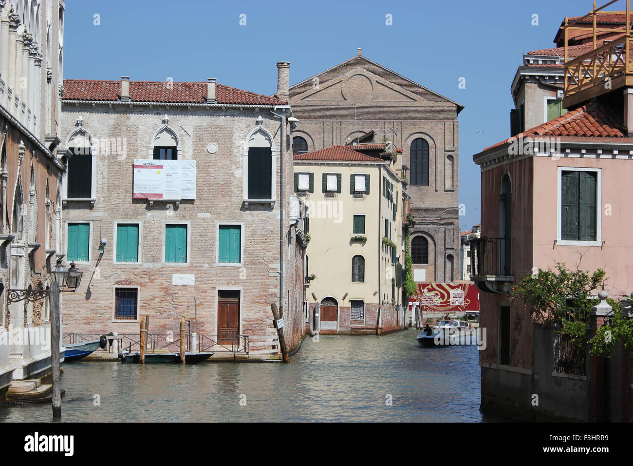 A boat moves along a canal in Venice Italy Stock Photo