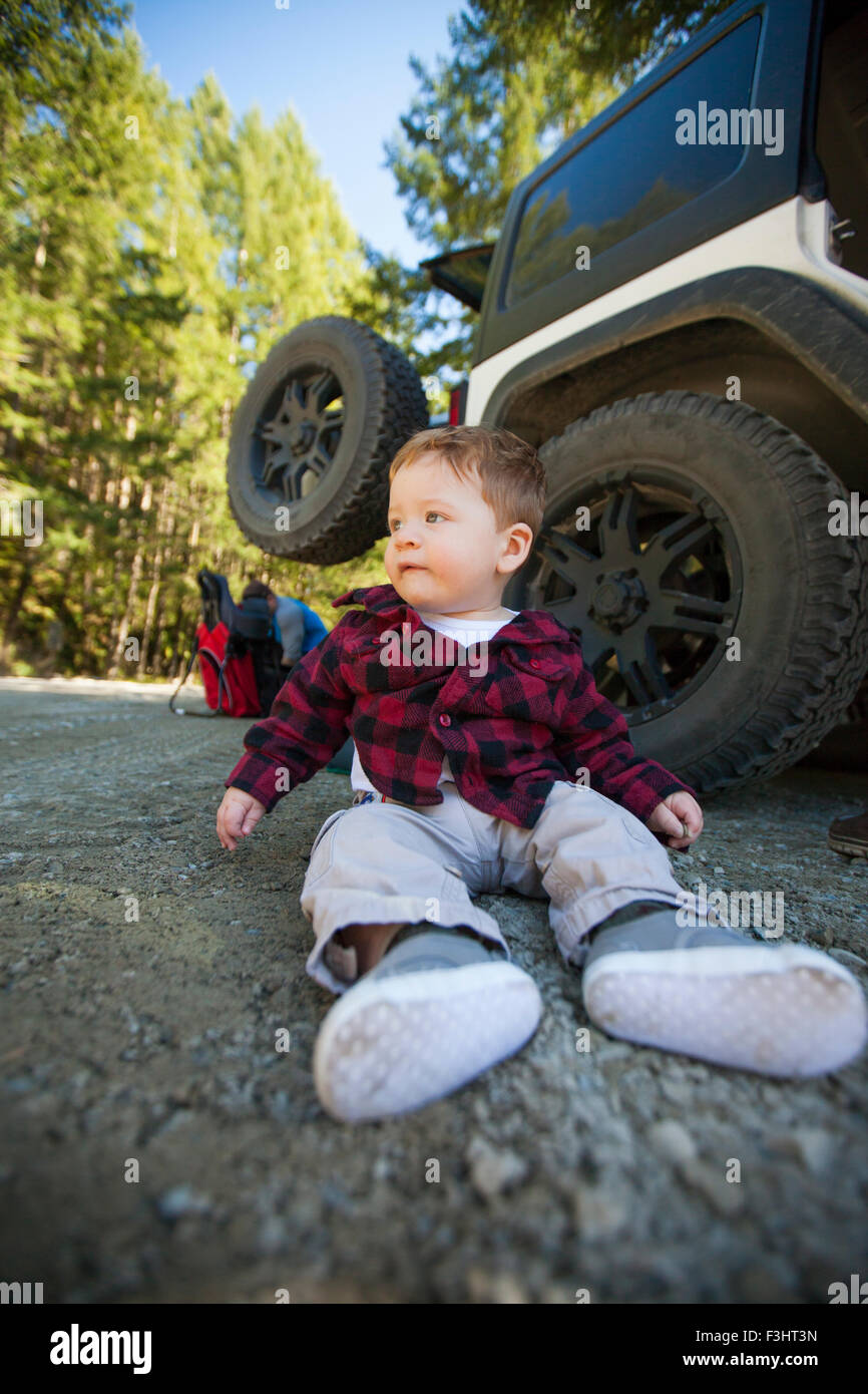 A young boy sitting in parking lot Stock Photo Alamy