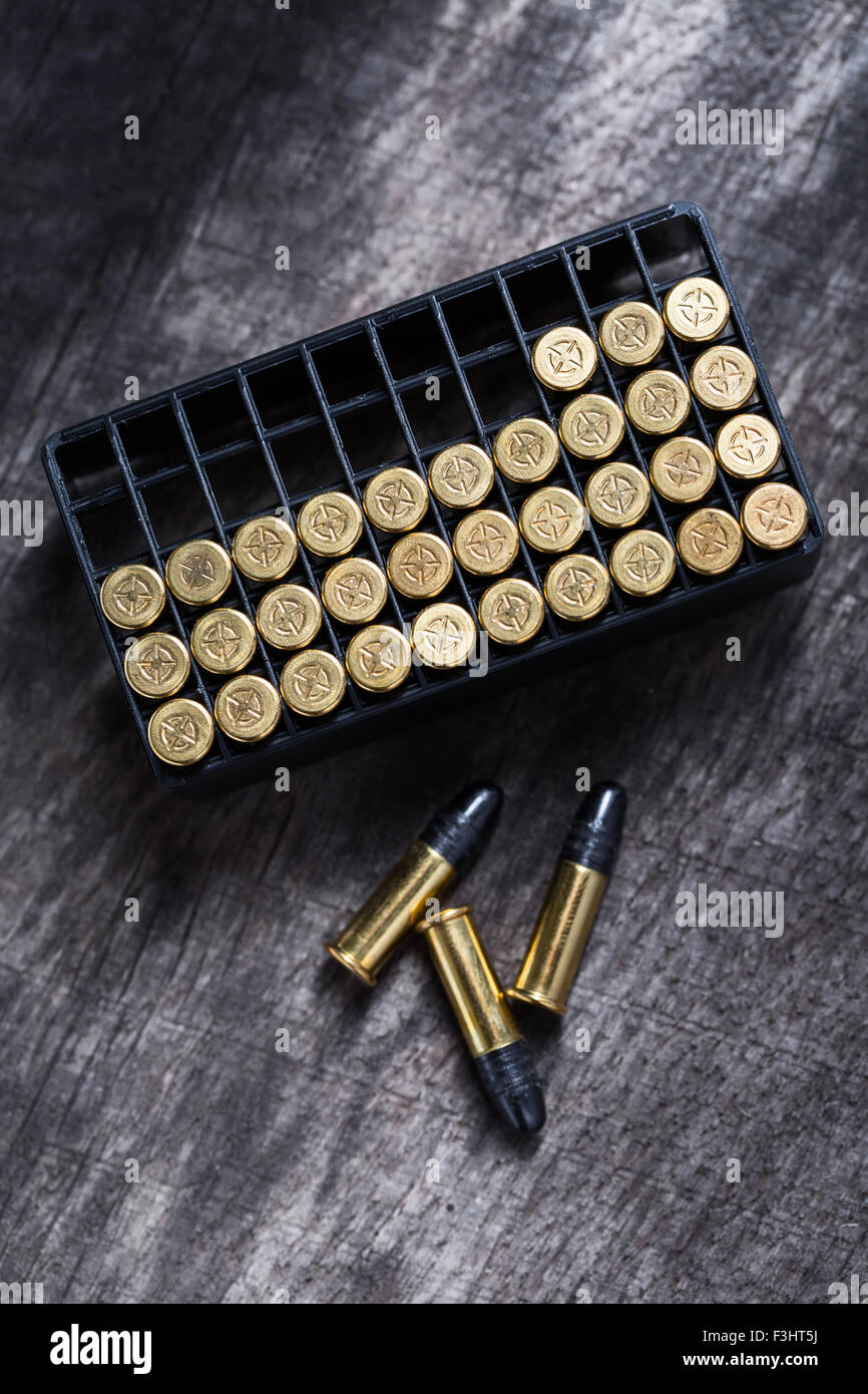 Scattering of small caliber cartridges on a wooden background Stock Photo