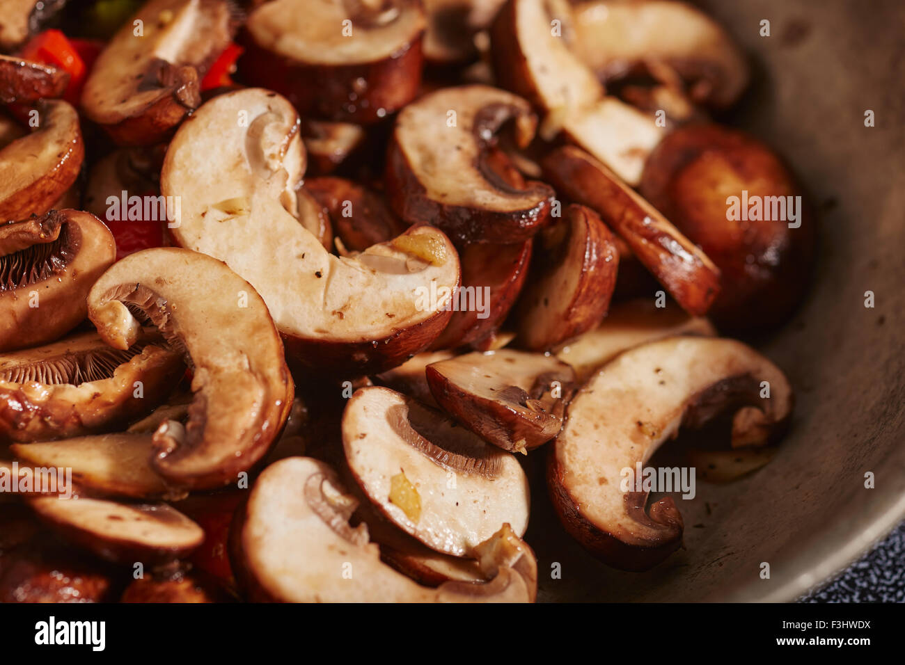 crimini mushroom slices frying in a skillet Stock Photo