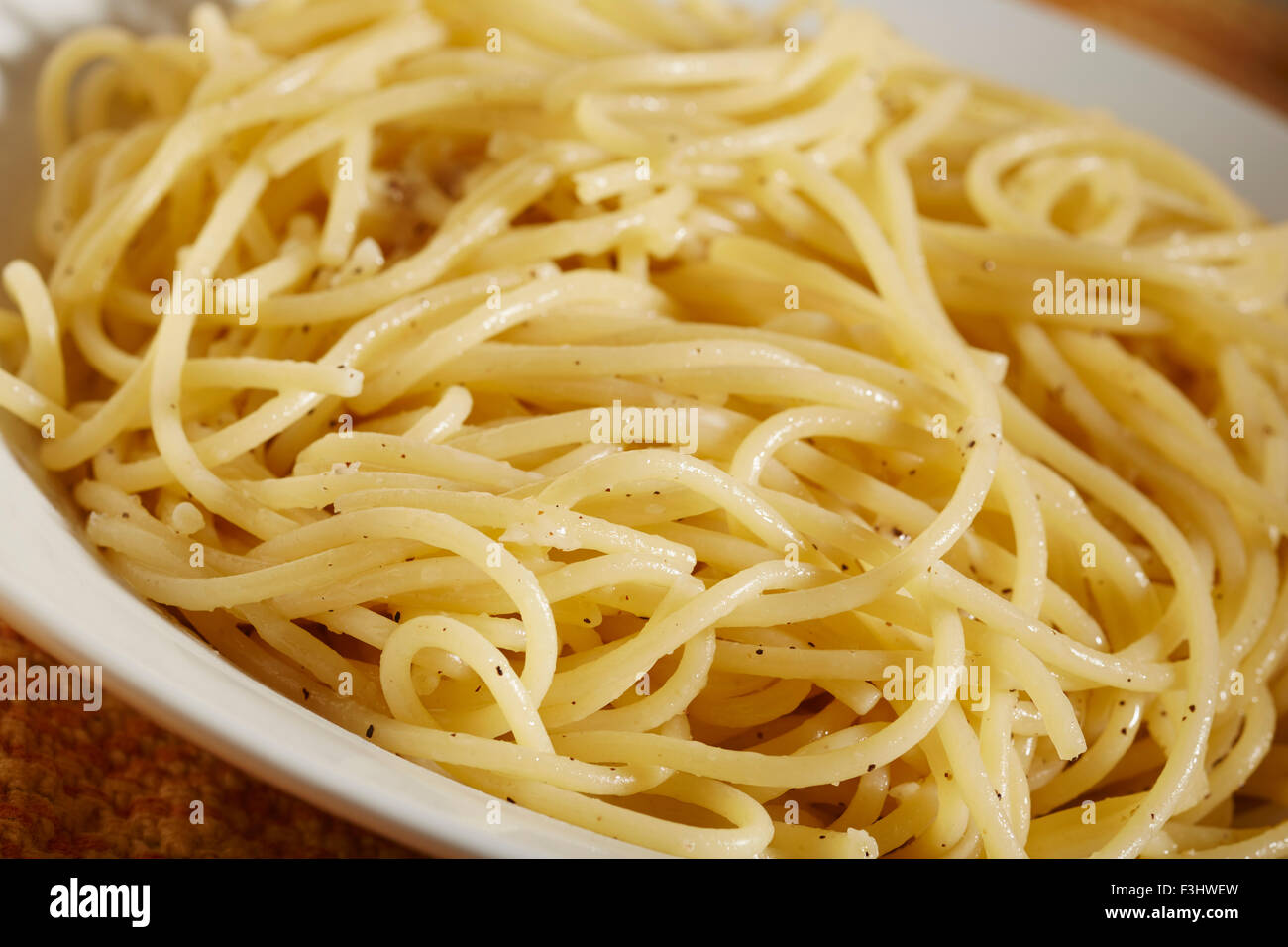 A bowl of cooked spaghetti with butter, salt and pepper Stock Photo