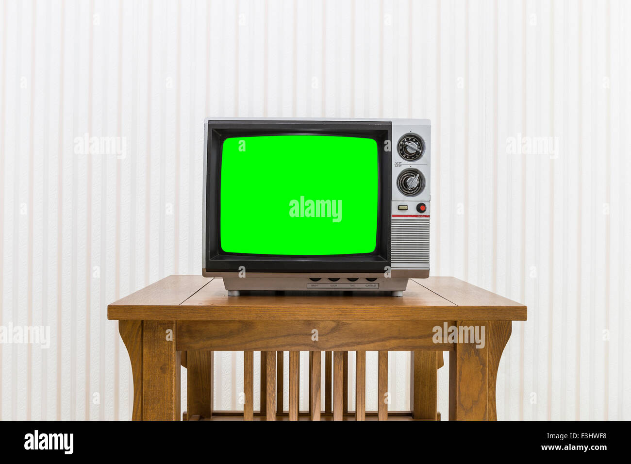 Old portable television on wood table with chroma screen Stock Photo
