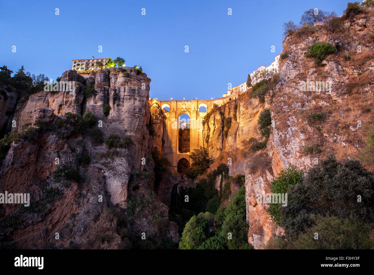 illuminated  Puente Nuevo Bridge from outskirts of Ronda at sunset, Spain Stock Photo