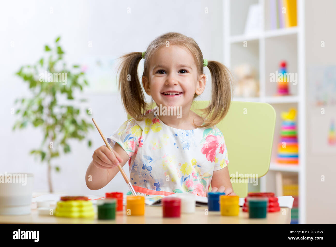 pretty kid girl painting with watercolours at home Stock Photo